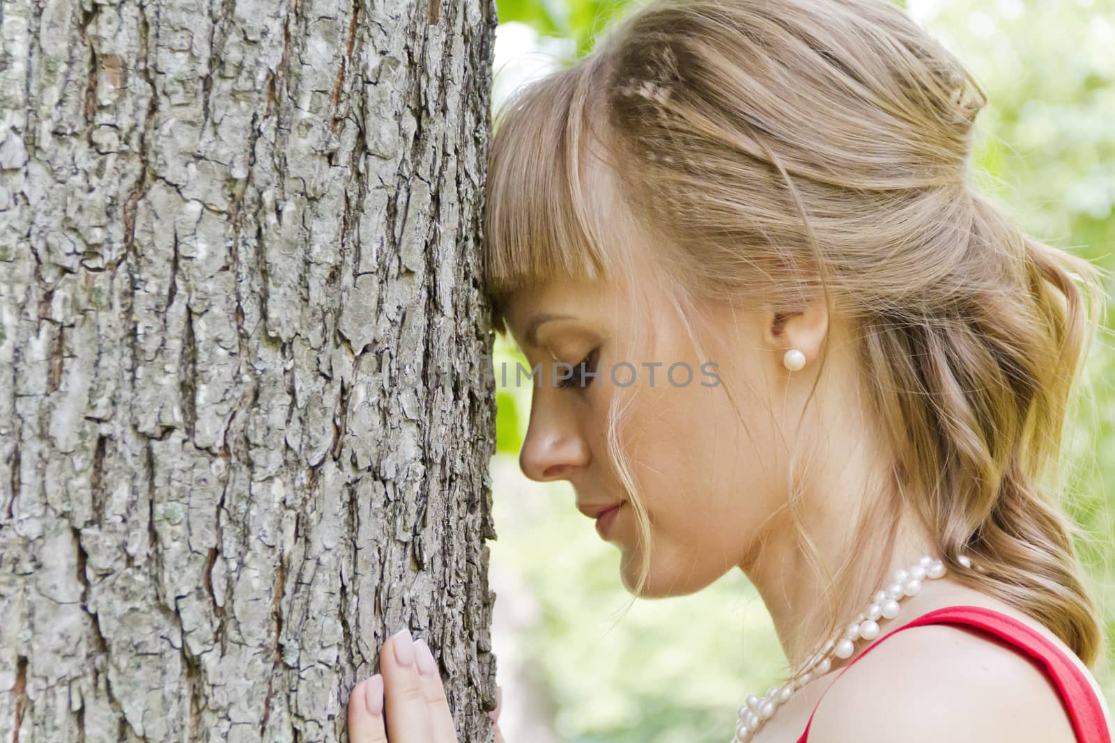 Beautiful lady in red are standing near tree summer day