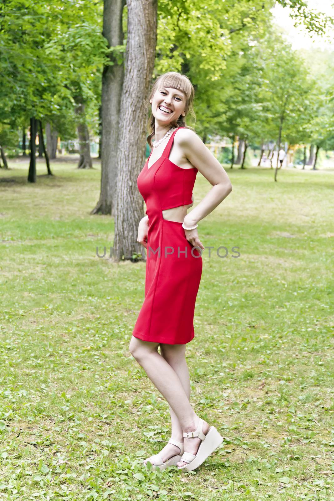 Beautiful lady in red are standing at the summer day