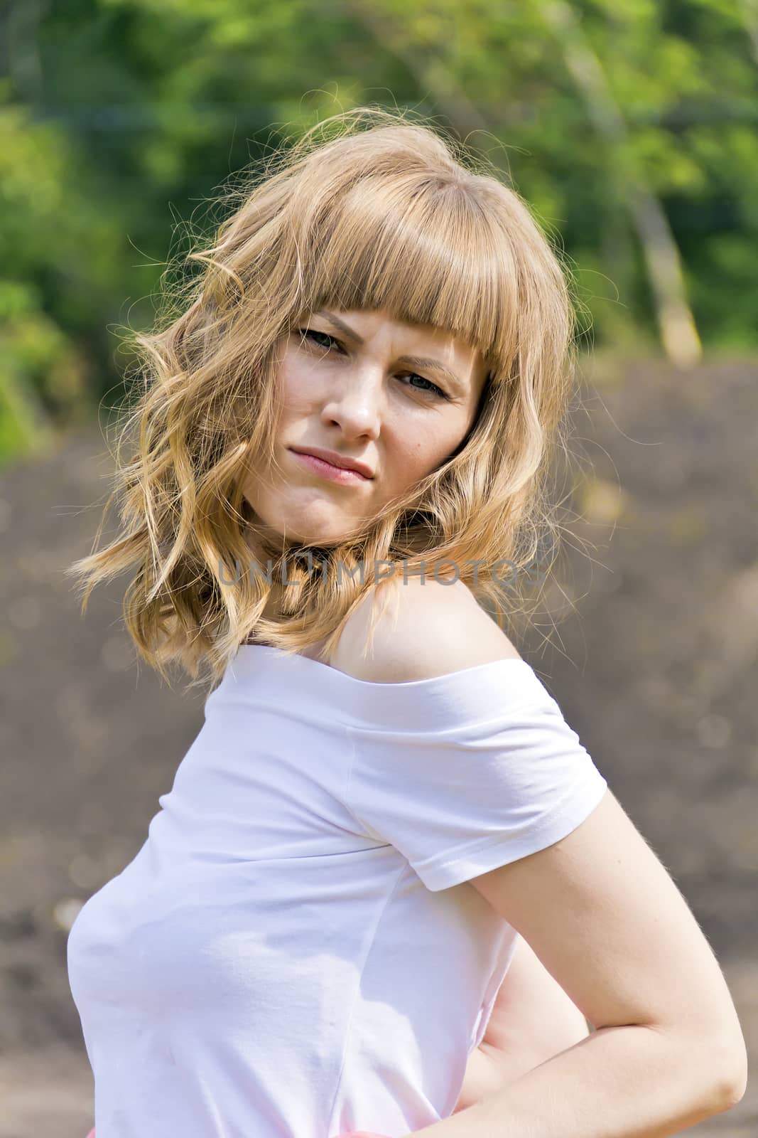 Vertical portrait of young woman with blond hair on wood background