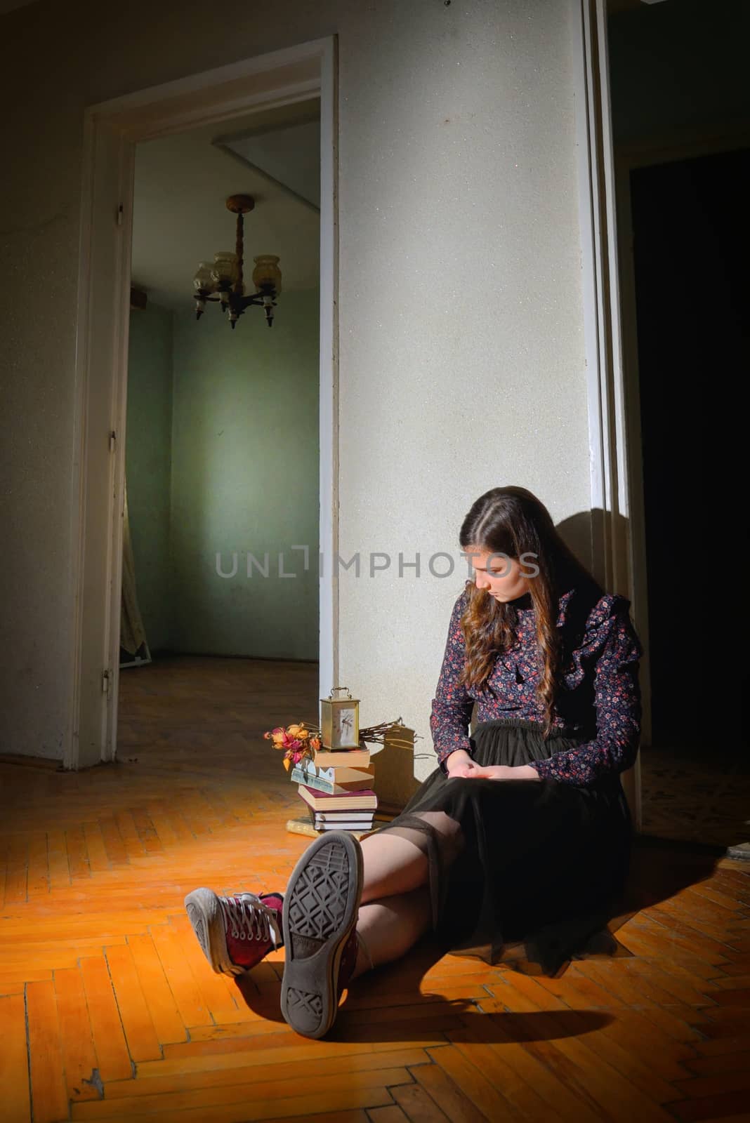 Young girl in black vintage dress in empty house
