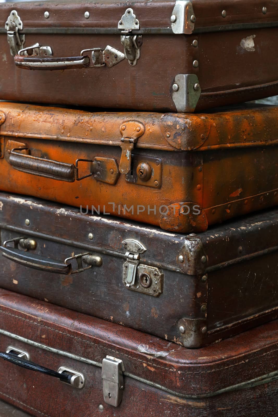 Stack of four old vintage antique grunge travel luggage brown leather suitcase trunks, close up, low angle side view