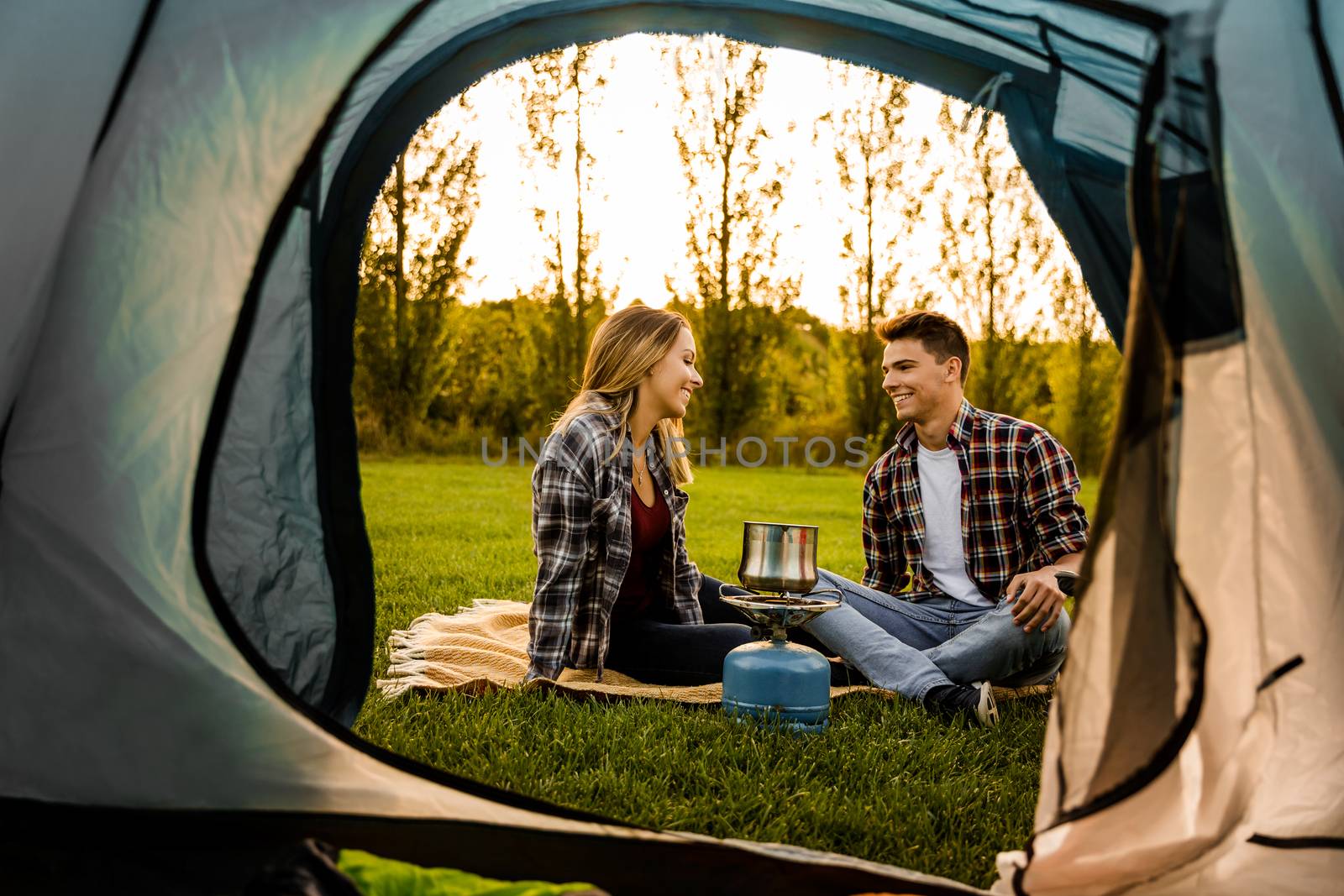 Shot of a happy couple camping on the nature and cooking