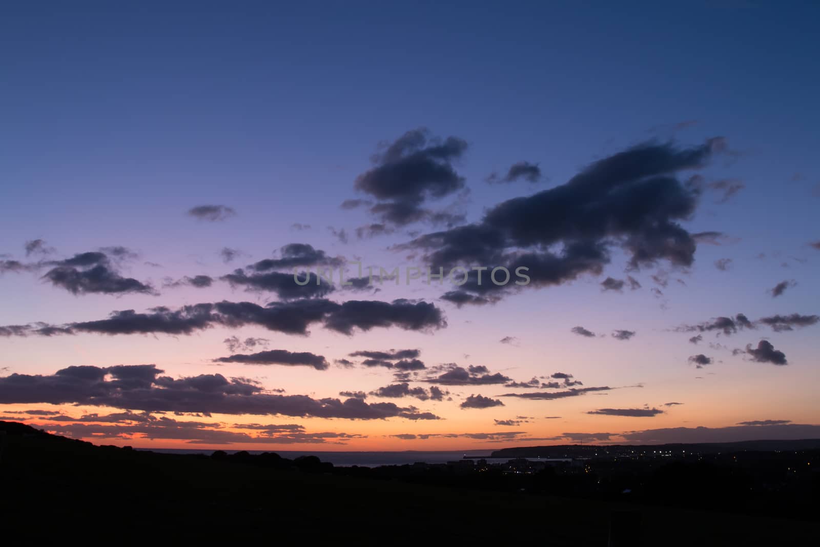 Evening sky just after sunset, with clouds and distant lights from Seaford and Newhaven.