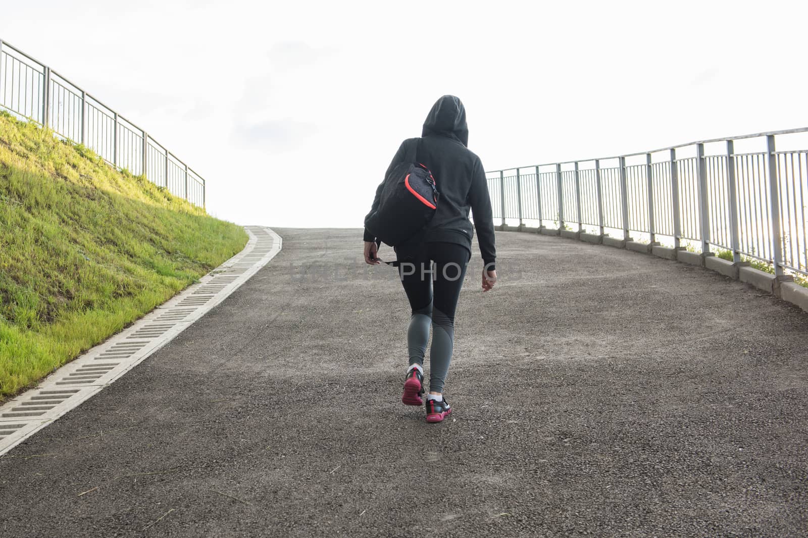 A woman in sportswear climbs the hill