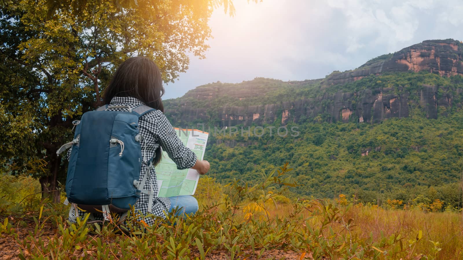 Hipster Asian woman backpacker look map on trip