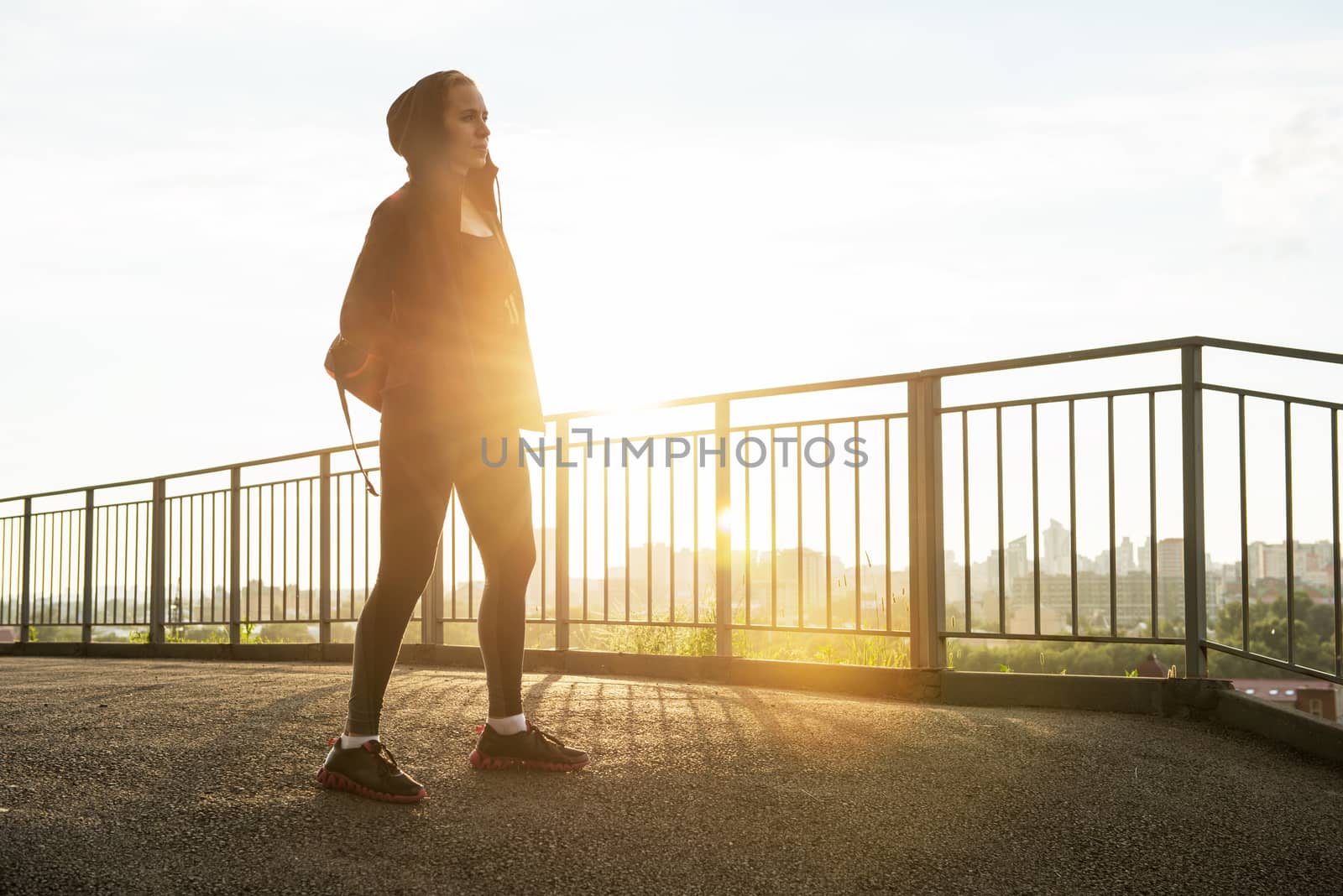 A woman in sportswear on evening city background