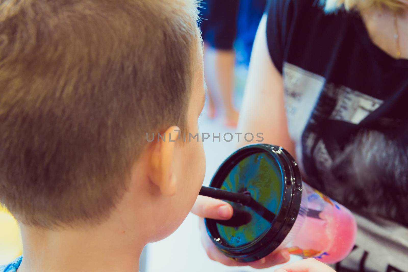 Young boy drinks sweet shaved ice at ice cream parlor