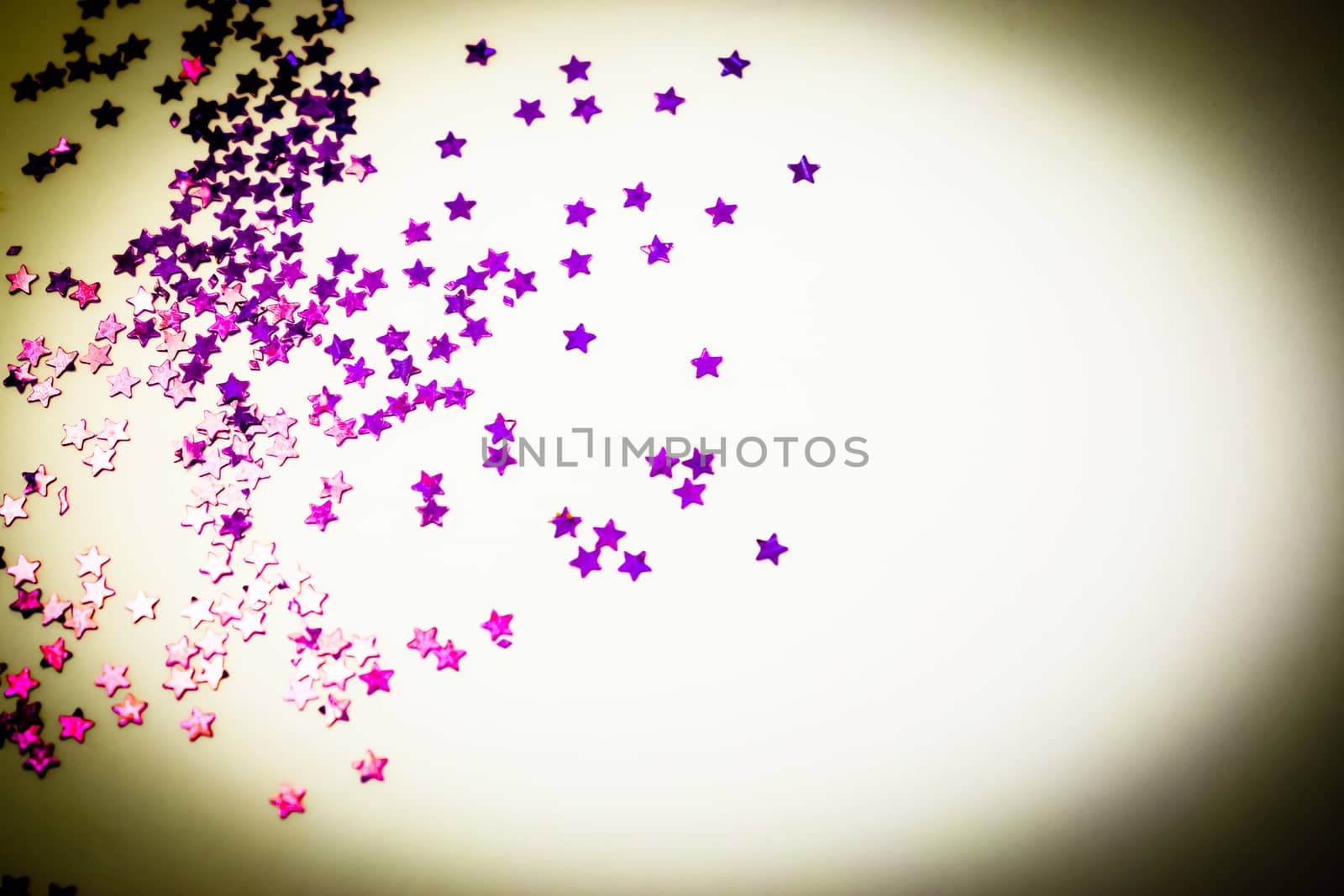 Purple glitter stars on a white background with copy space