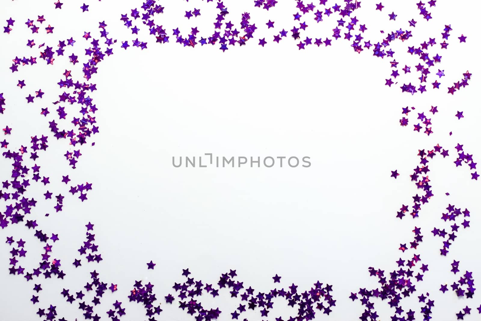 Purple glitter stars on a white background with copy space