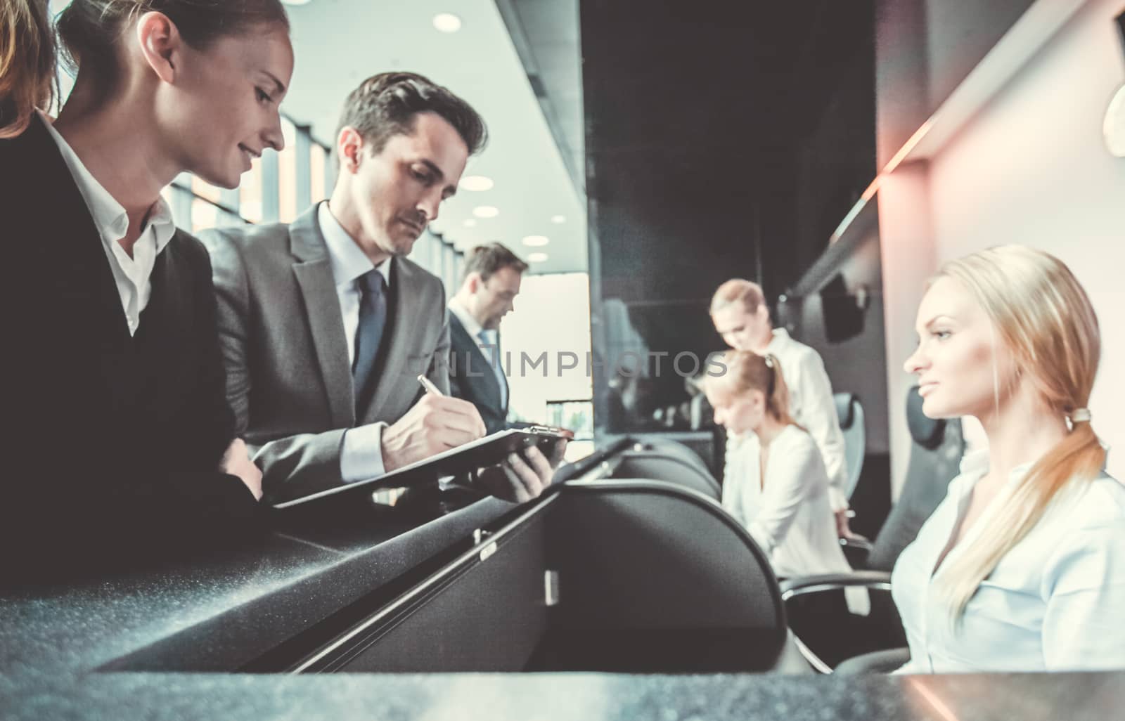 Business people filling forms at reception front desk