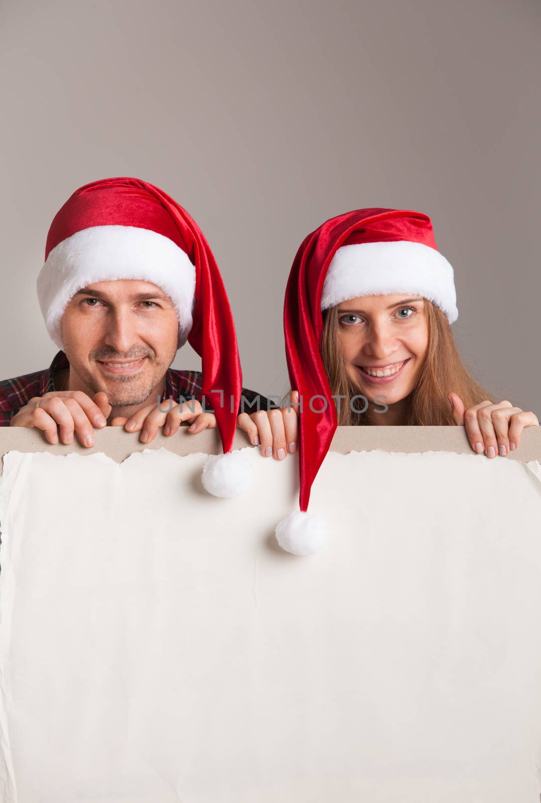 Couple in Santa hats with banner by ALotOfPeople