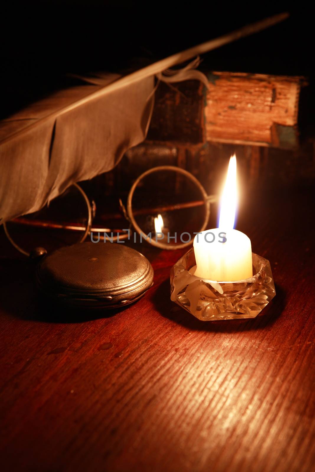 Vintage still life with lighting candle near old things