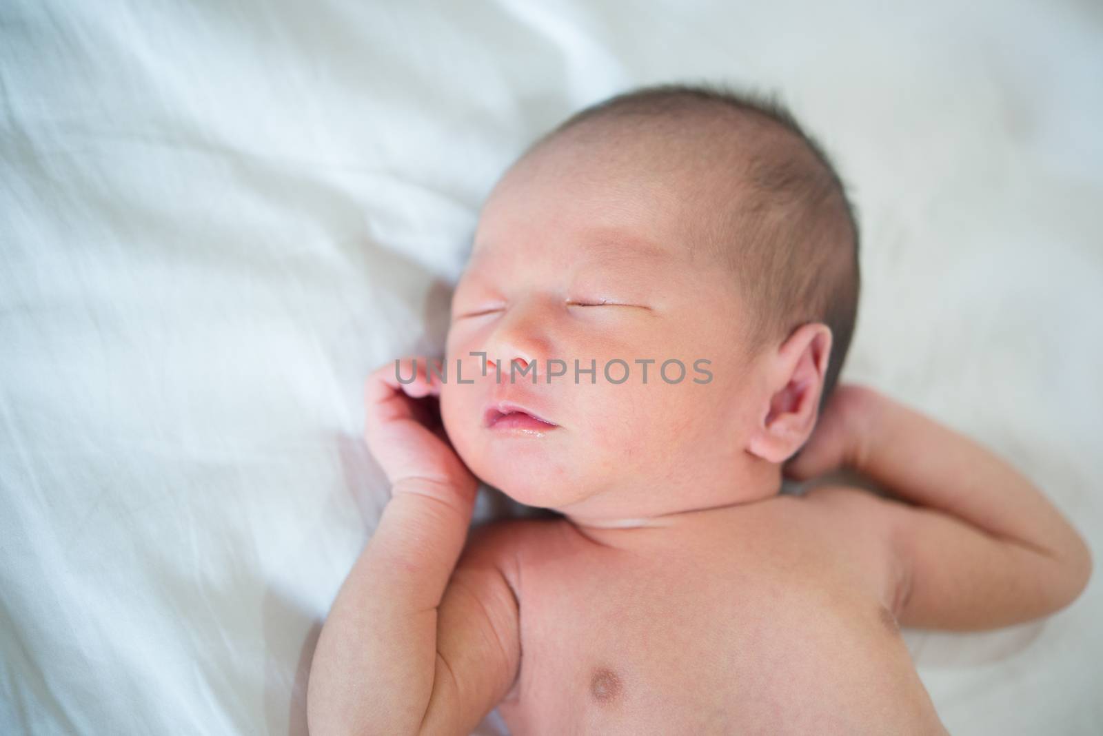 Asian newborn baby sleeping in bed. 1 week old.