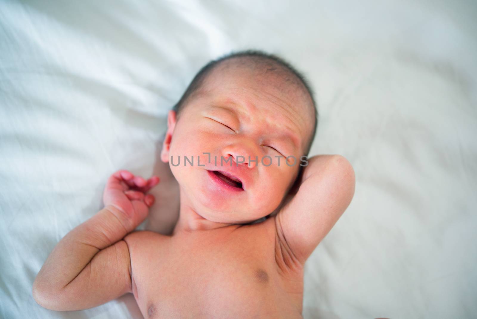 Newborn baby crying on the bed, selective focus