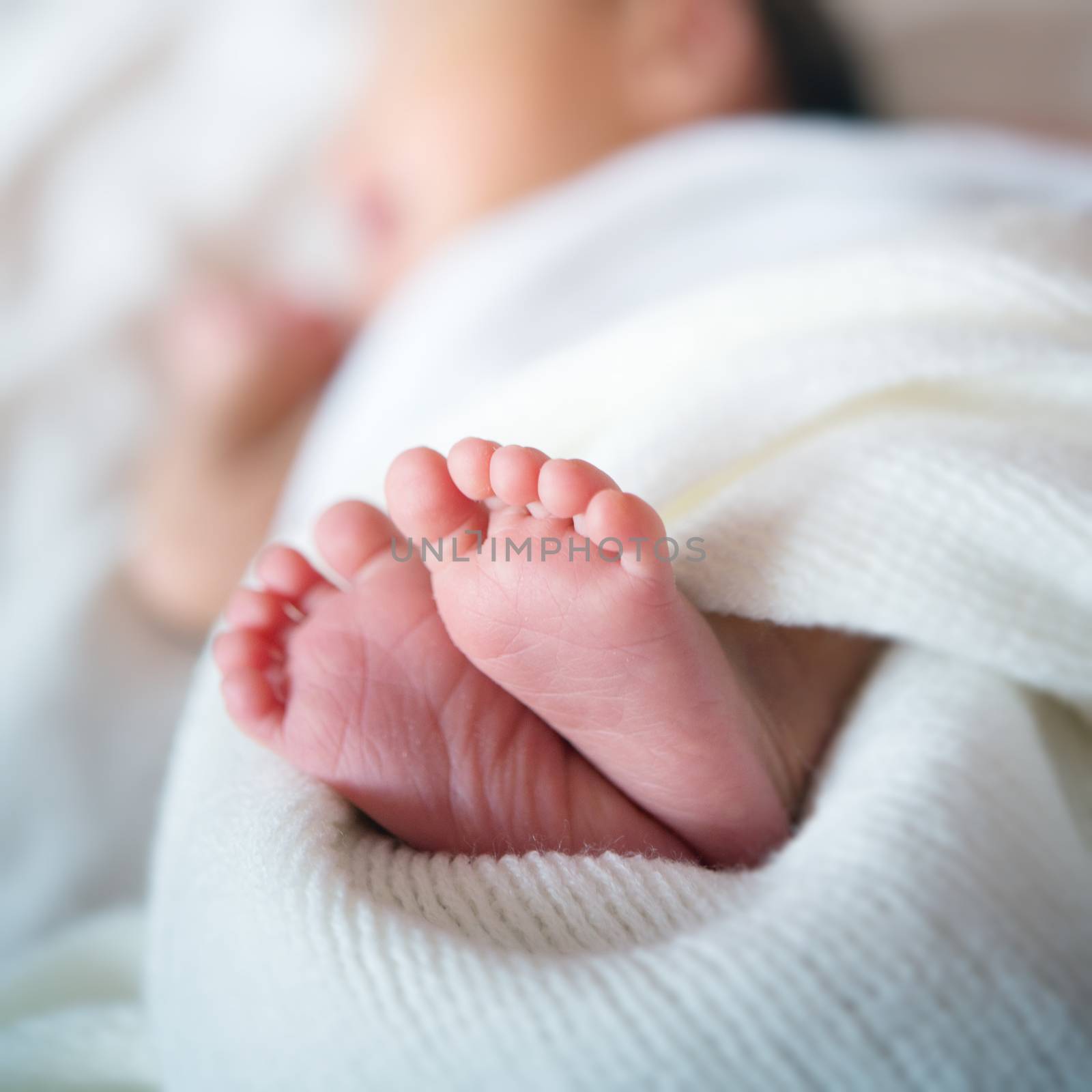 Newborn baby feet in bed by szefei