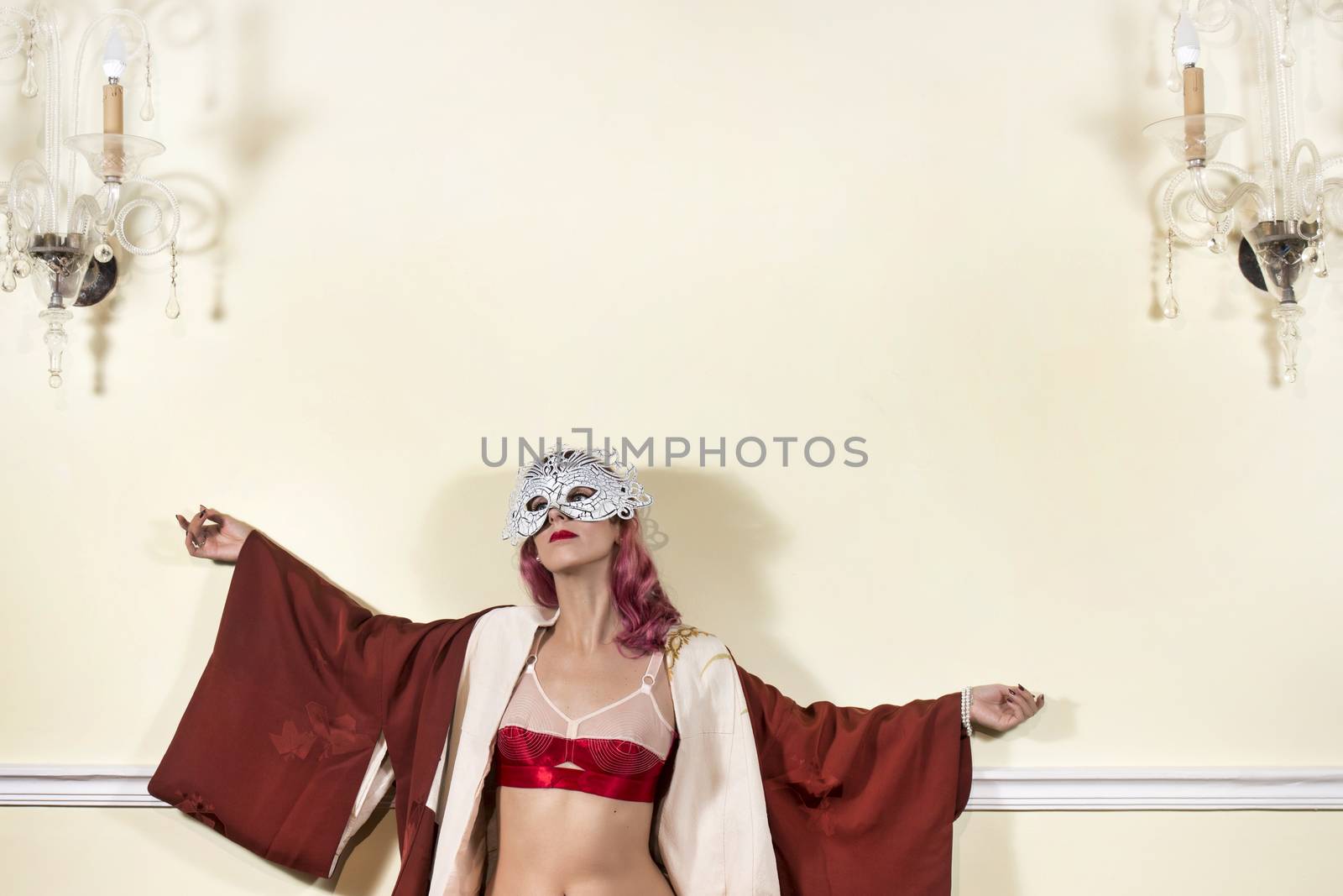 Girl with red vintage lingerie with a striped sofa in the living room.