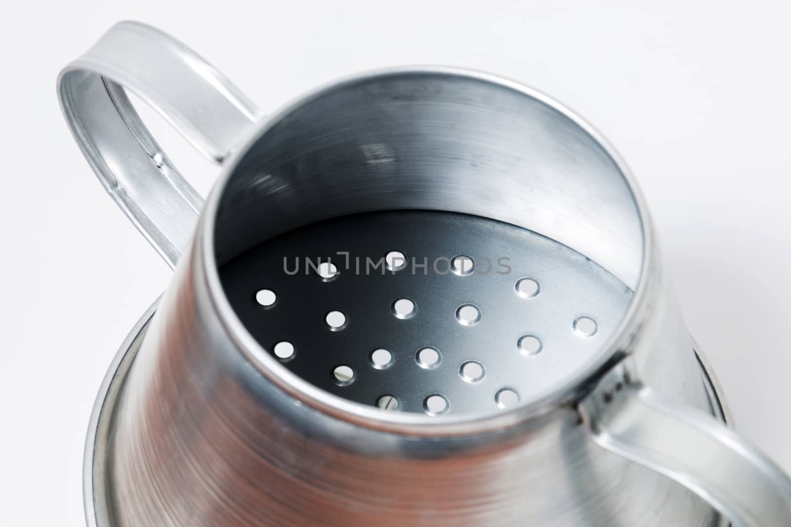 Close view of a metal rustic chestnut roaster isolated on a white background.