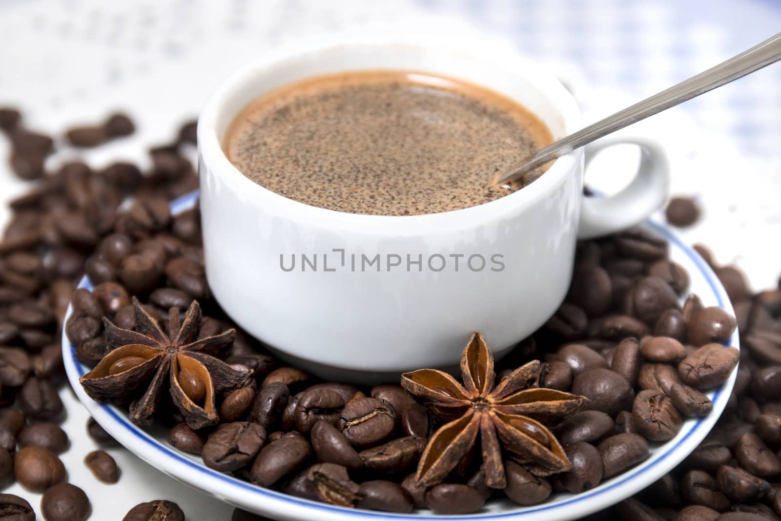 Composition of a coffee cup with spreaded beans and star anise.