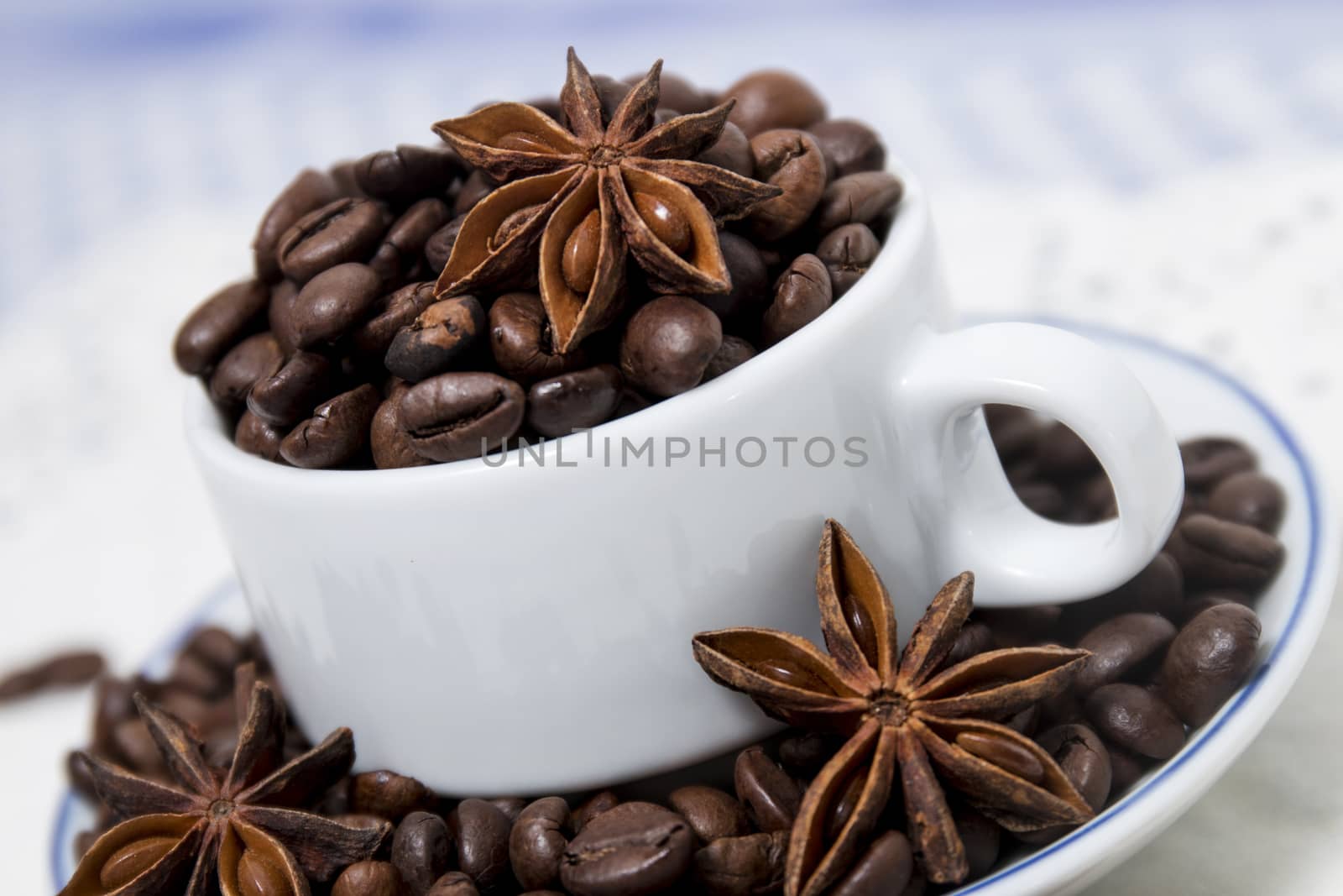 Composition of a cup full of coffee beans on table.