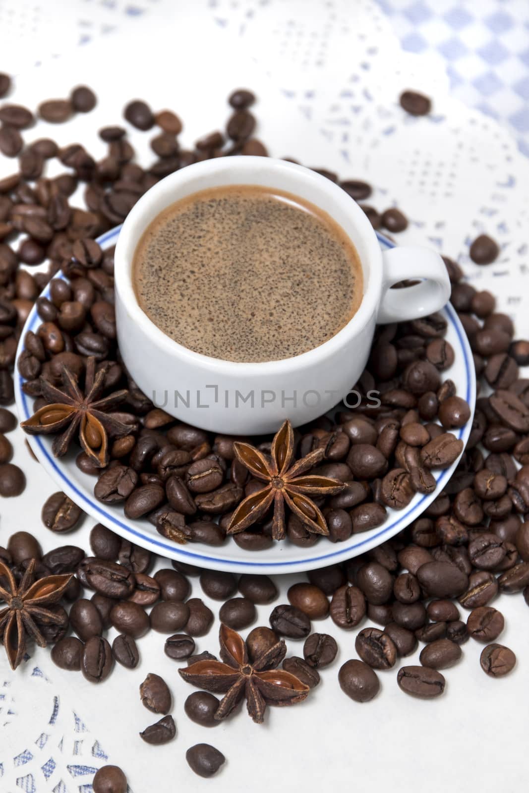 Composition of a coffee cup with spreaded beans and star anise.