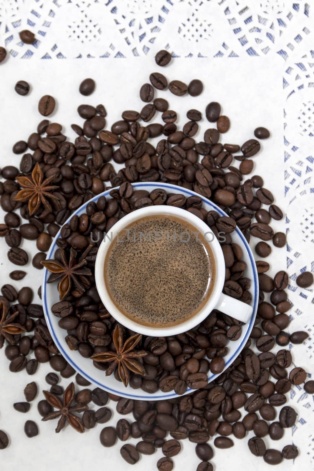 Composition of a coffee cup with spreaded beans and star anise.