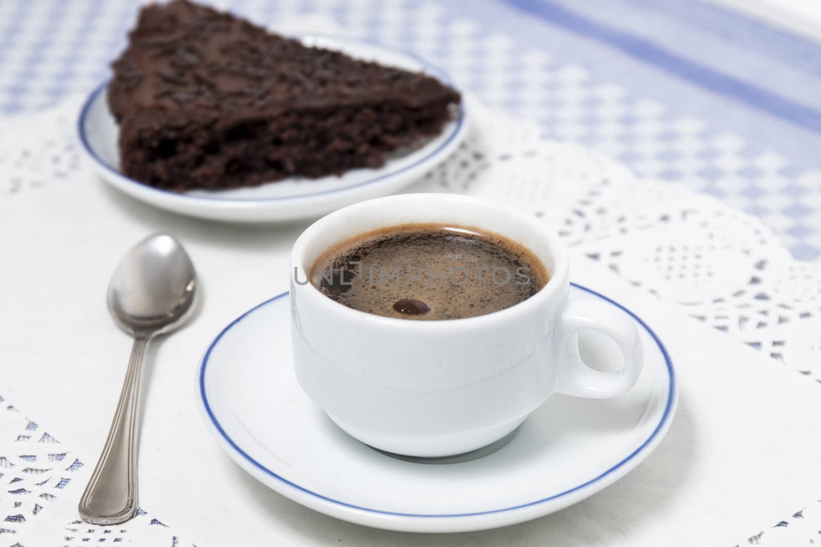 Composition of the classic coffee cup espresso with a piece of brigadeiro cake.