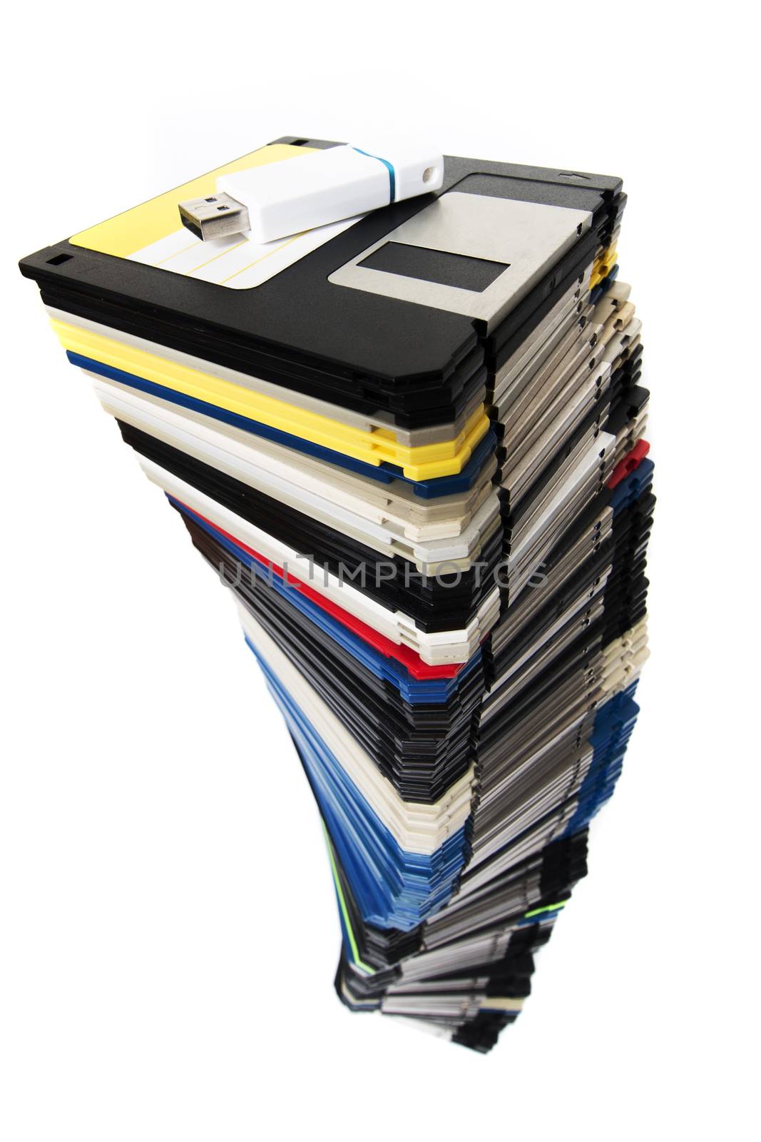Vertical pile of computer floppy disks with usb disk isolated on a white background.