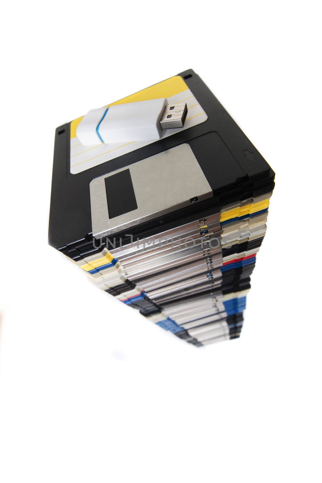 Vertical pile of computer floppy disks with usb disk isolated on a white background.