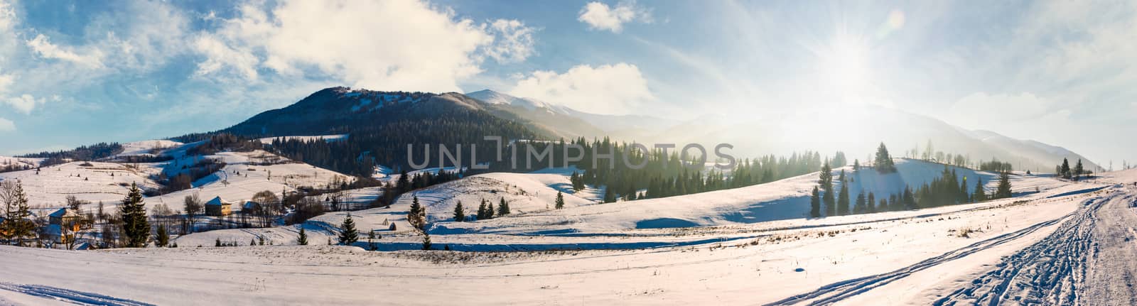 forested valley of Pylypets village in Carpathians. Gorgeous winter landscape with Borzhava mountain ridge on winter sunny day