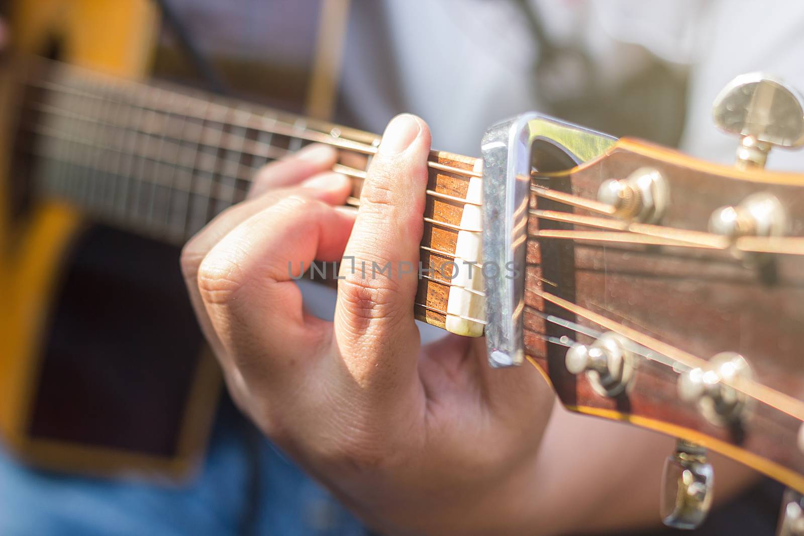 closeup of man's hands playing acoustic guitar, soft vintage style