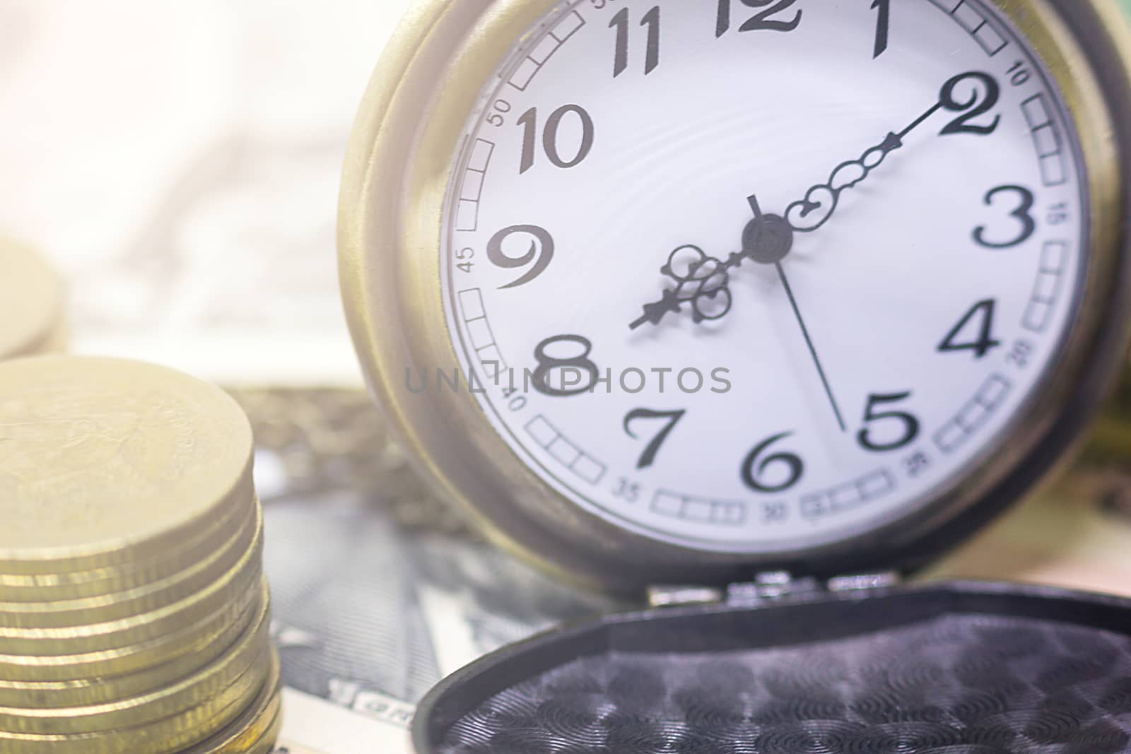 classic pocket watch and coins on dollar banknote, concept and i by rakoptonLPN