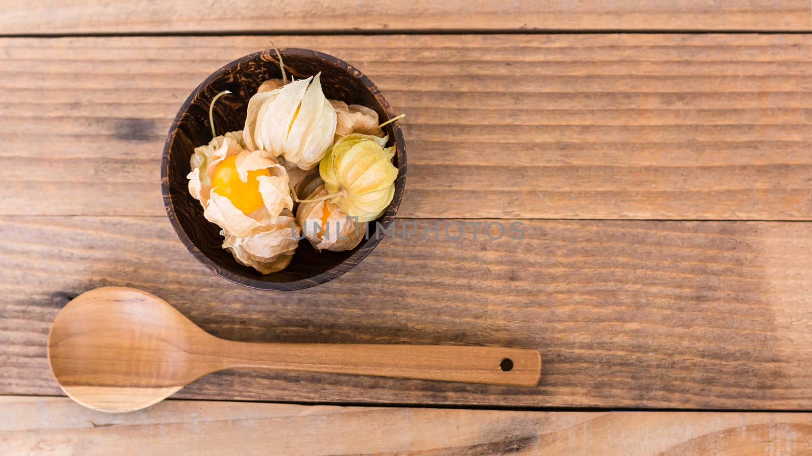 top view of cape gooseberry (Physalis) in wooden bowls and woode by rakoptonLPN