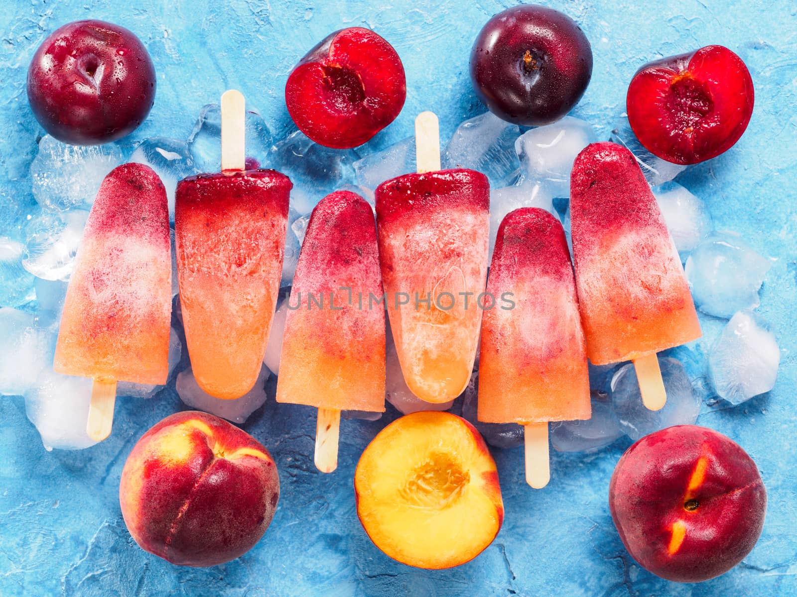 top view of plum and peach popsicle on blue background by fascinadora