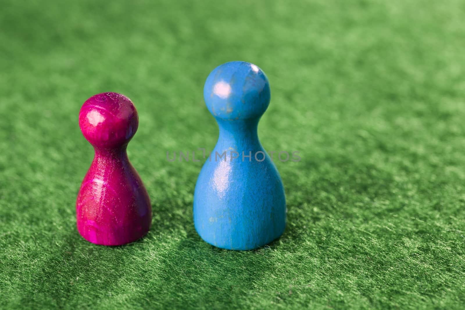 Two different pawns on a green felt table