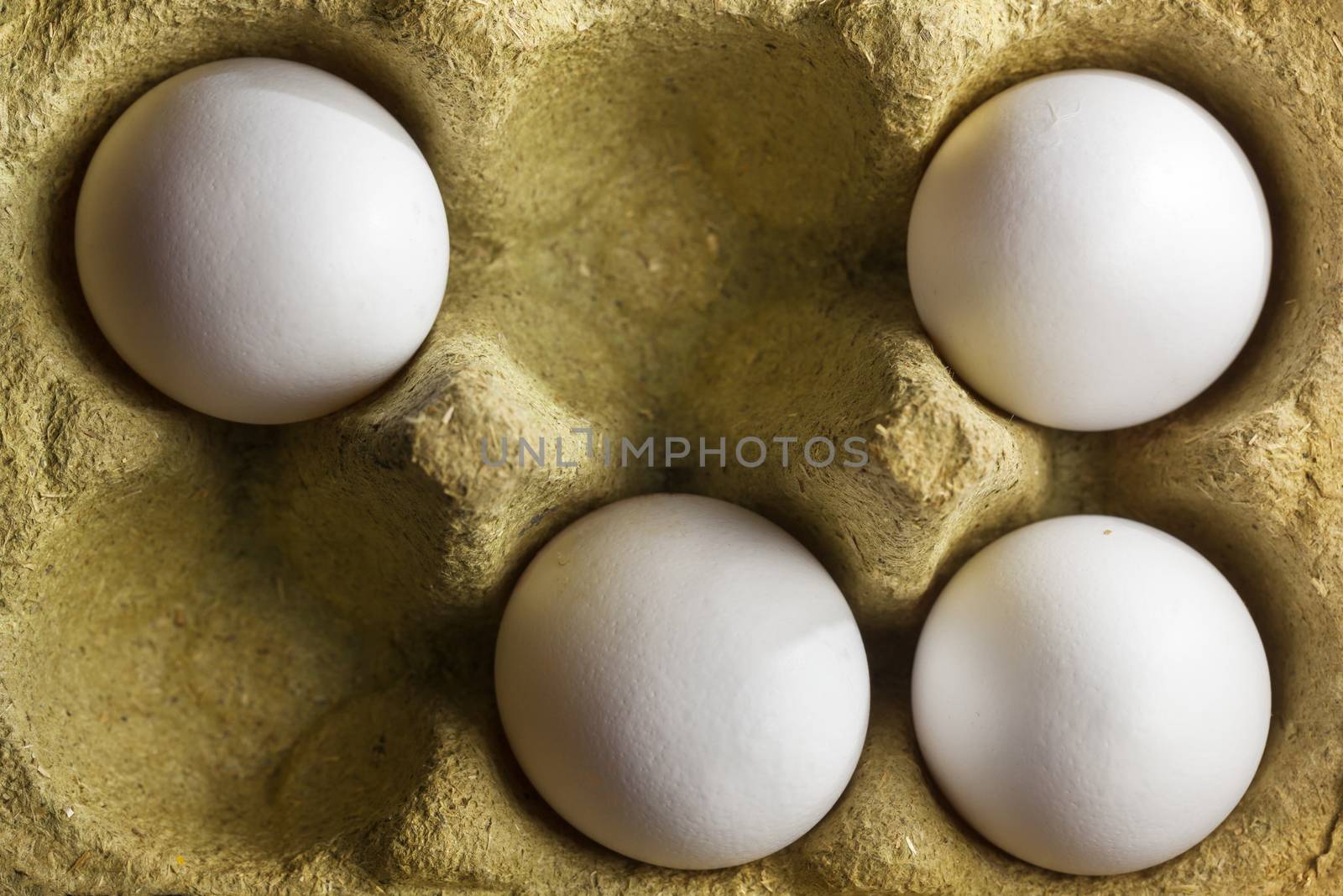 Four organic eggs in a box made of grass by kievith