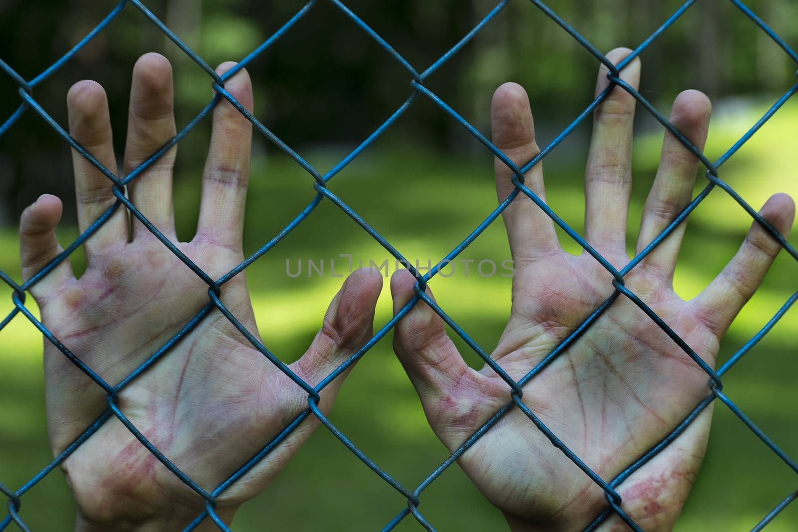 Man hands in jail. Imprisonment. Poverty, suffering.