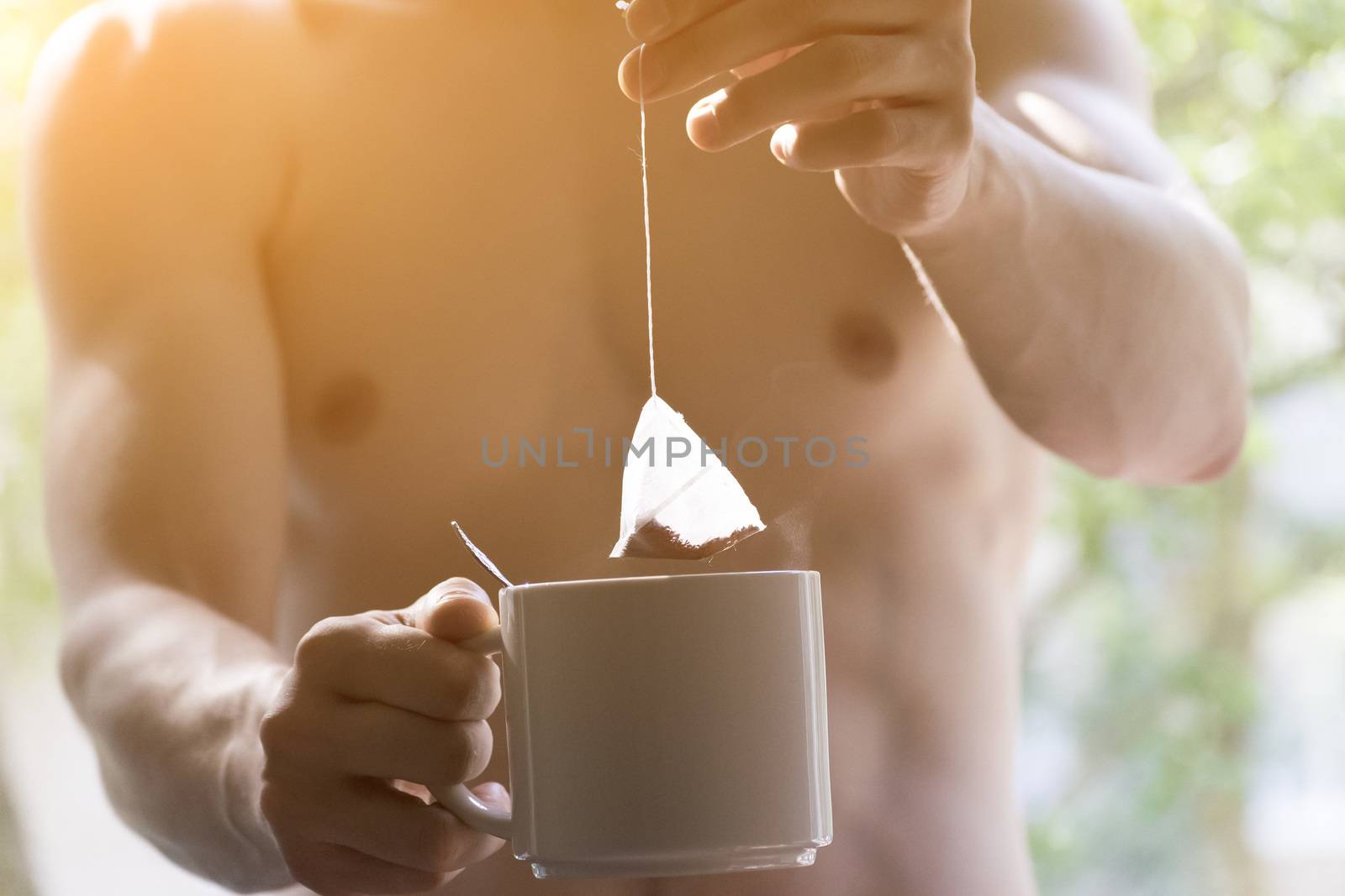 The young man brewing the tea bag. Morning awakening.