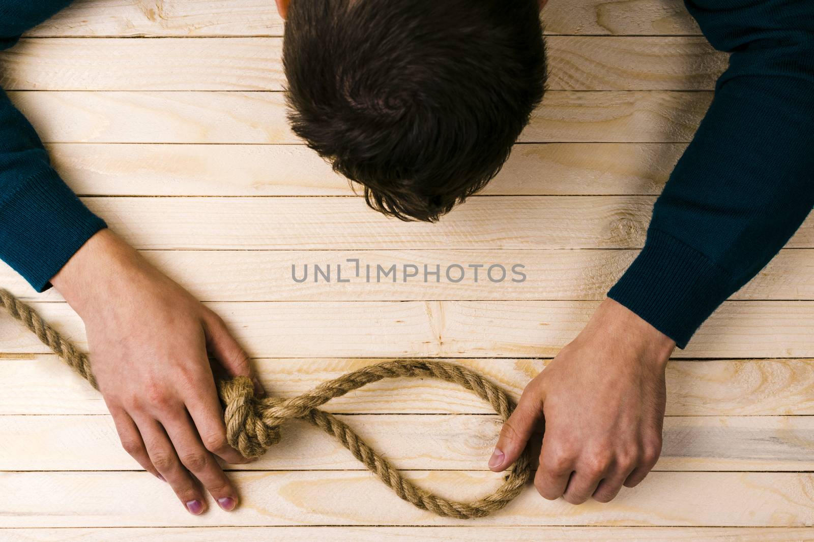 A man holds a loop of rope in his hands. A mental health day.
