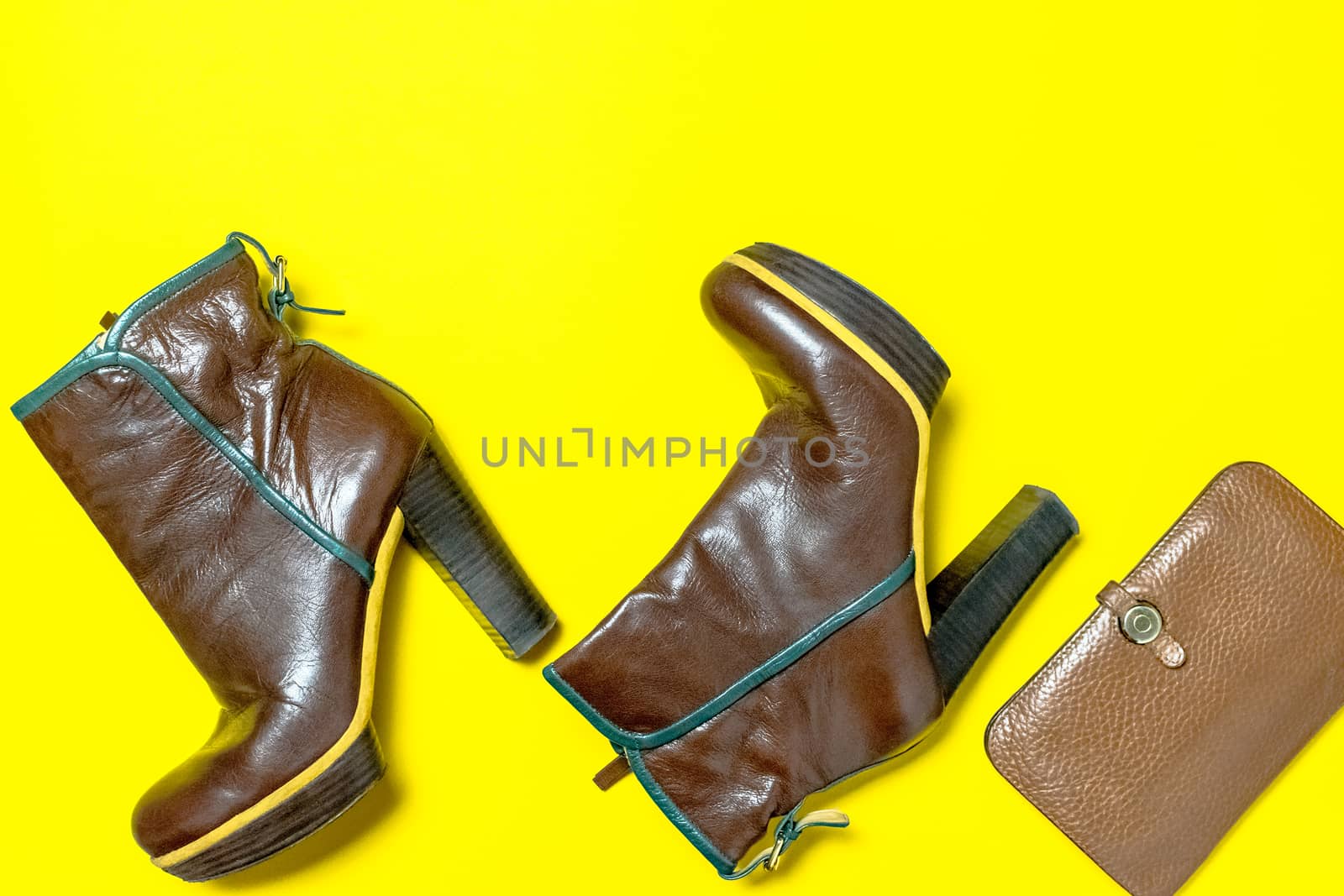 Female shoes, bag, autumn leaves on a yellow background. The concept of autumn.