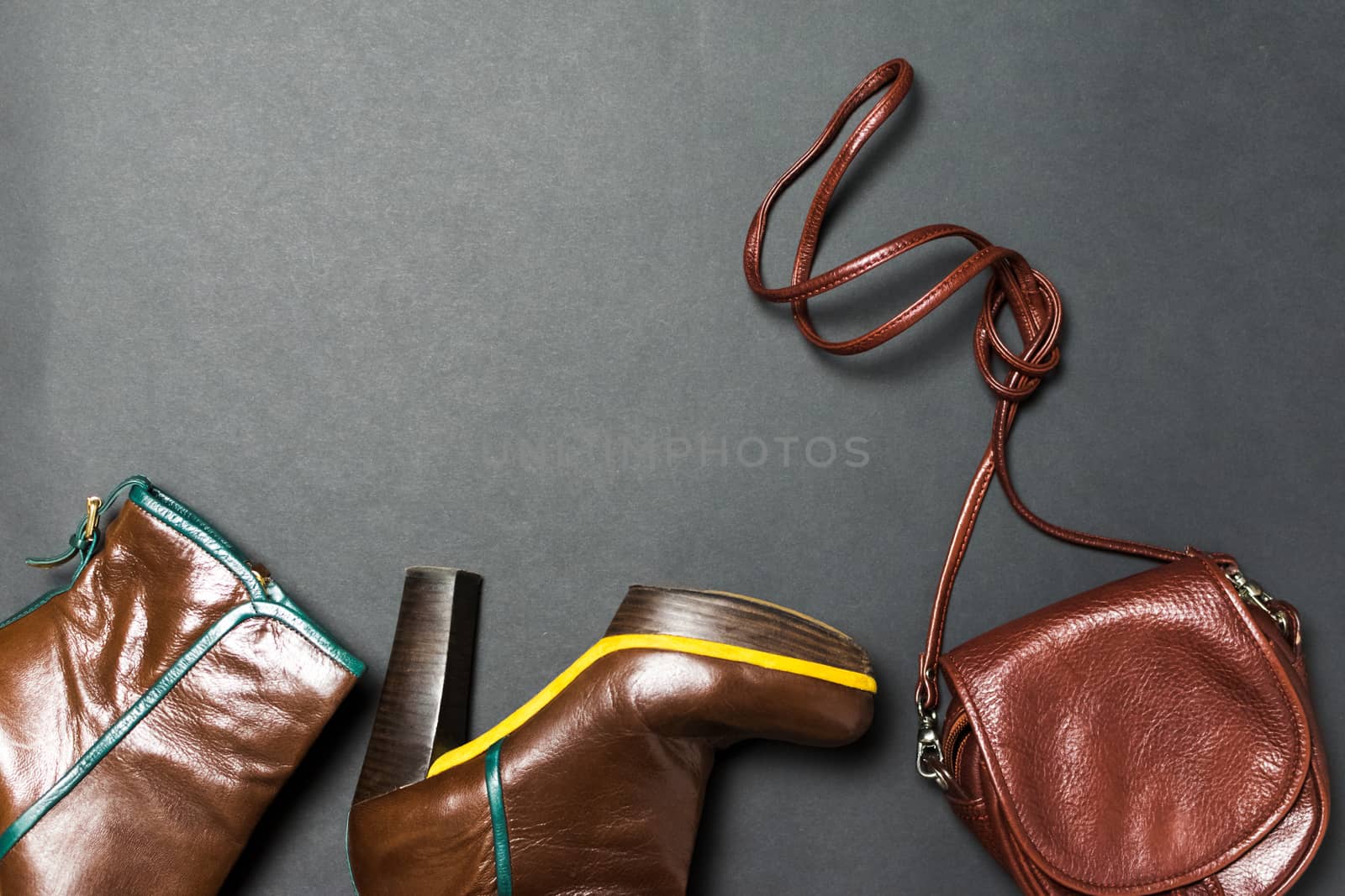 Female shoes, bag, autumn leaves on a black background. The concept of autumn.