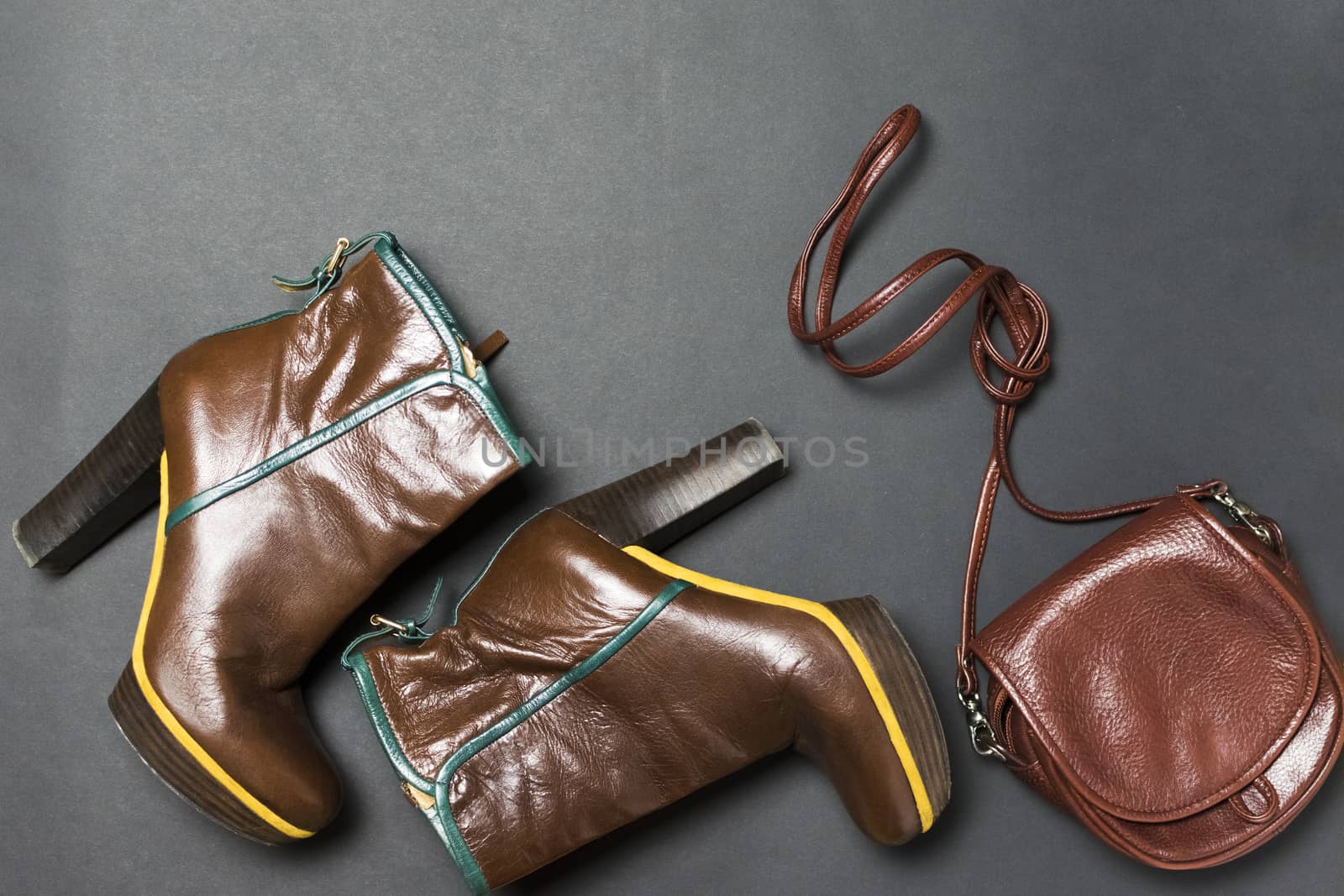 Female shoes, bag, autumn leaves on a black background. The concept of autumn.