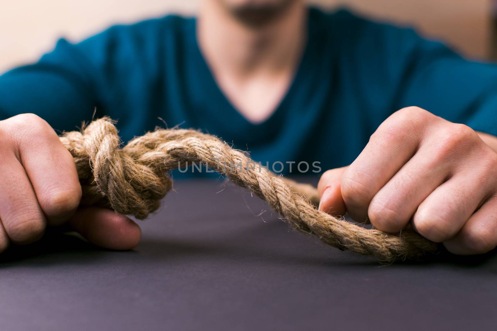 A man holds a loop of rope in his hands. A mental health day.