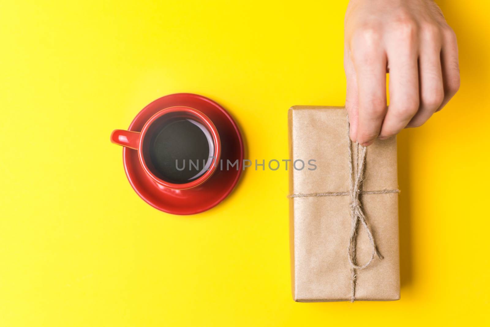 The man pulls a gift to yourself. Still life on yellow background
