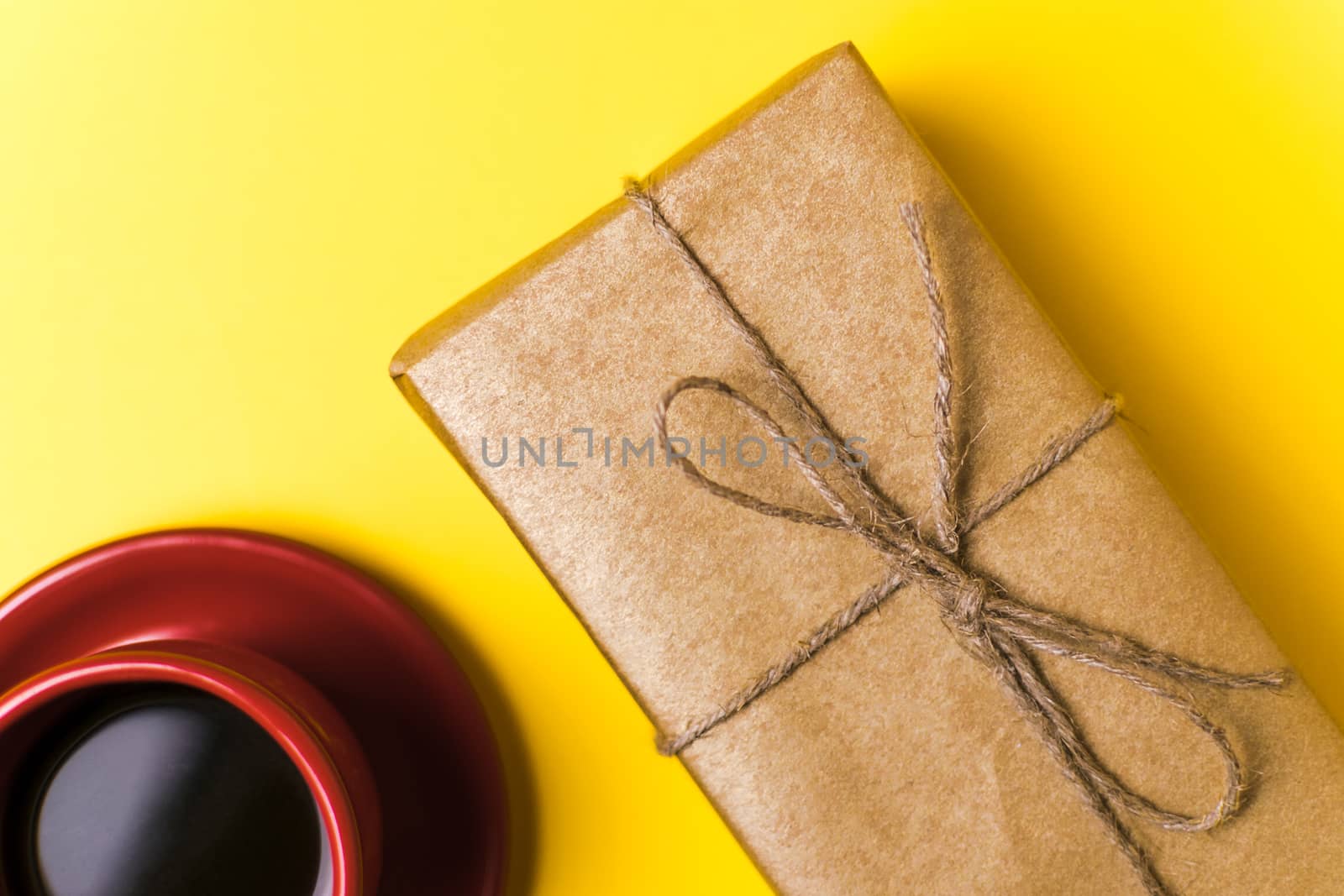 Red Cup with coffee and gift on yellow background