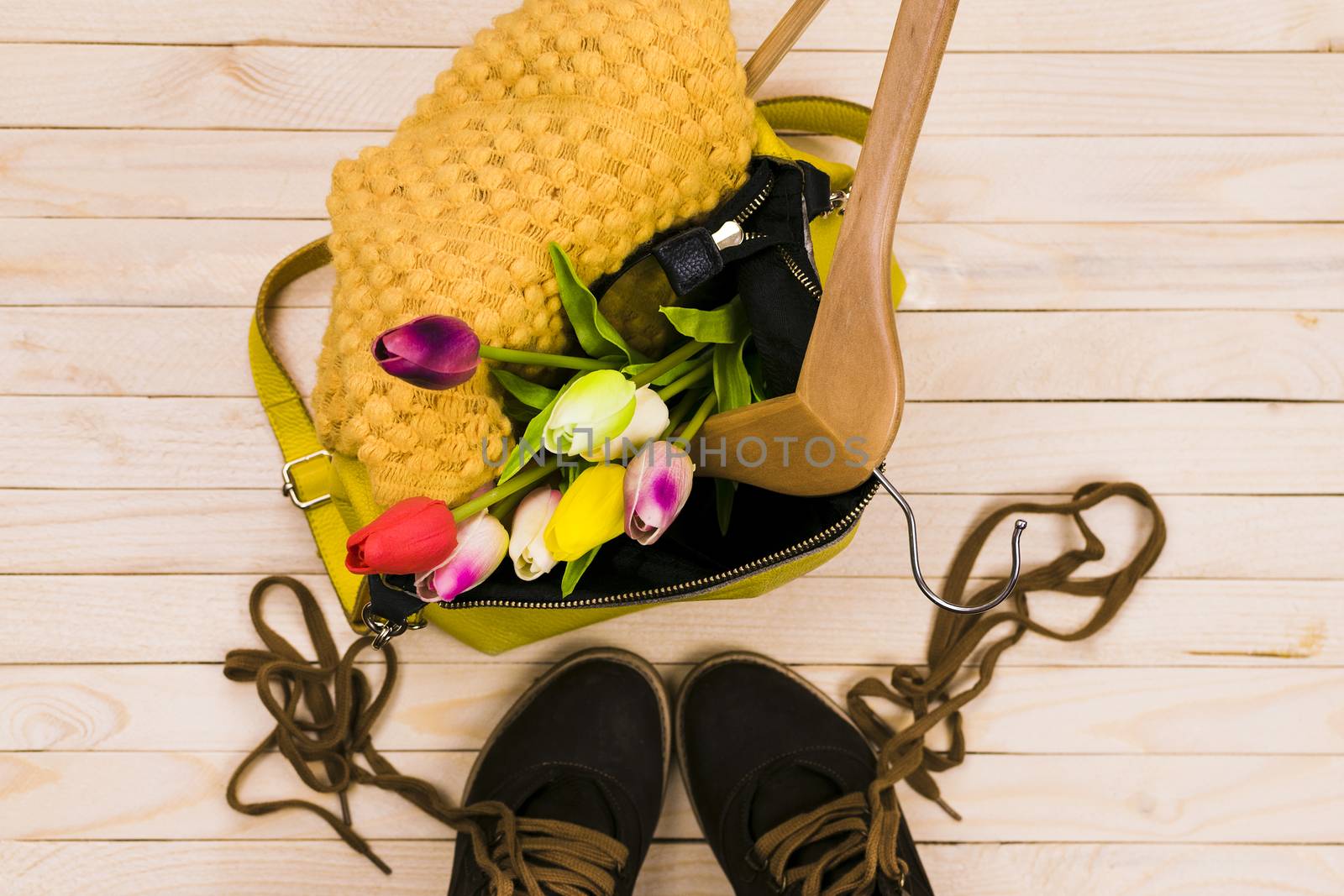 Women's bag with clothes and shoes on a colored background