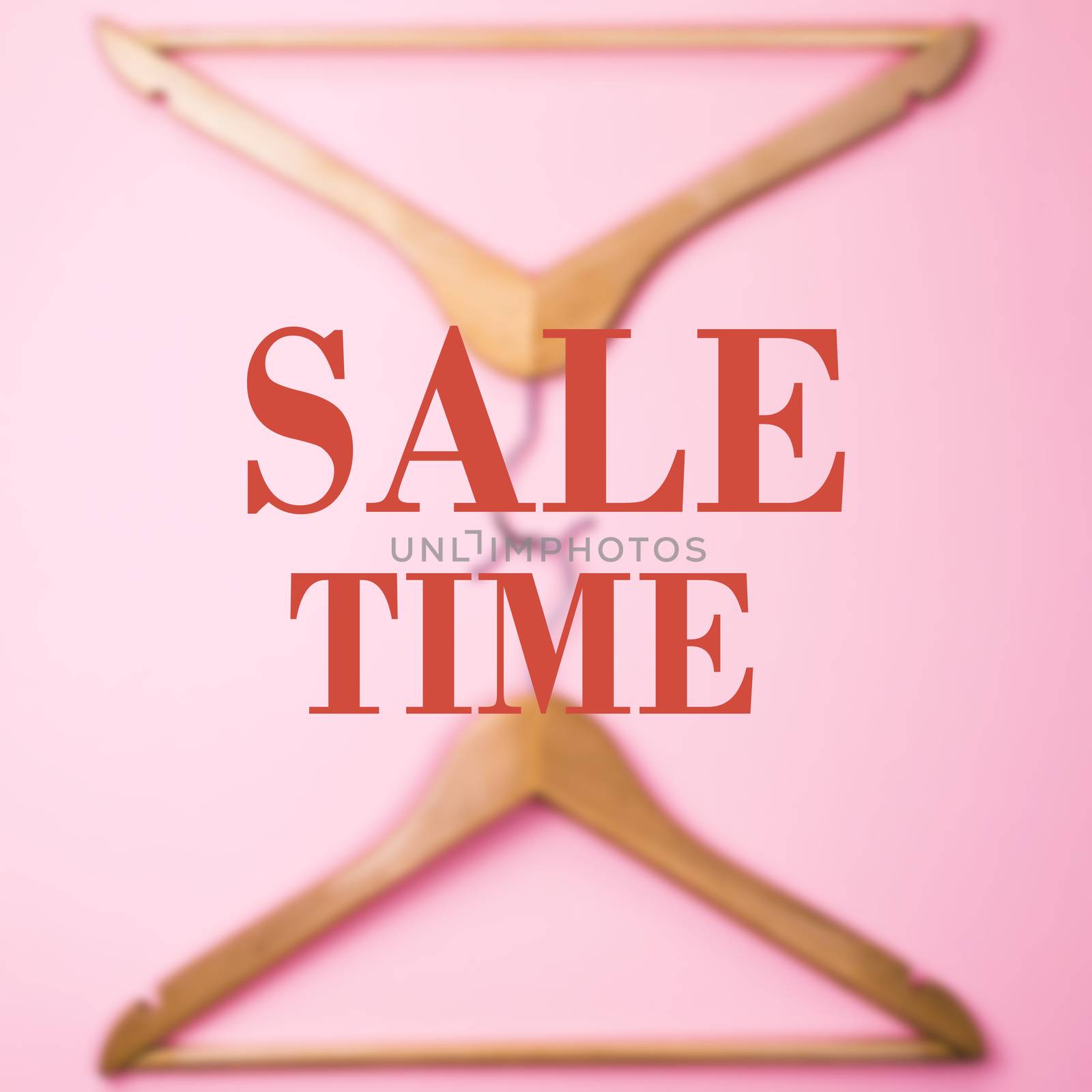 Pair of wooden hangers on a pink background and the words "sale Time"