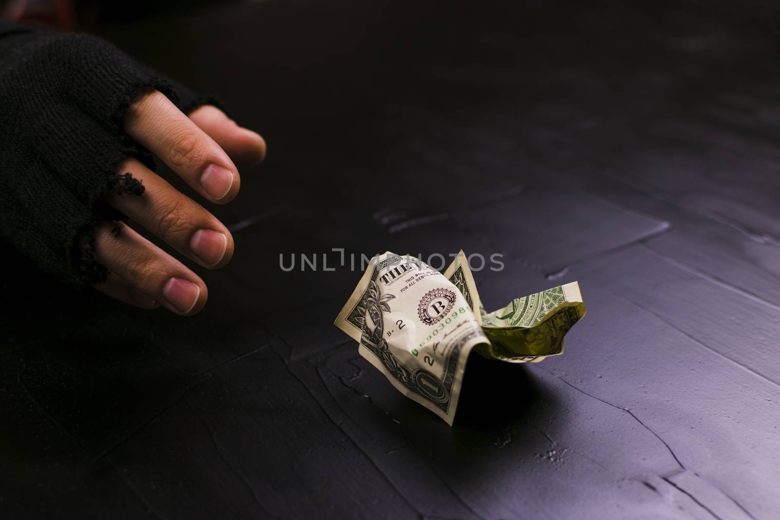 The man reaches for a dollar bill. Day for the eradication of poverty.