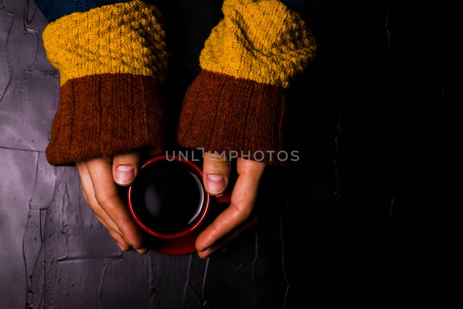 A man holding a Cup of coffee on black background