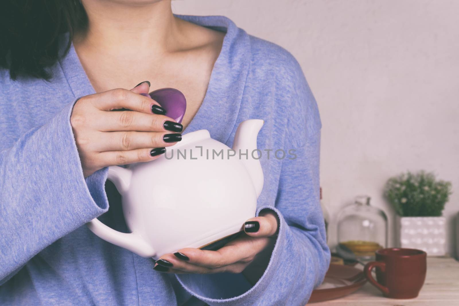 A girl drinks tea in the morning in the kitchen