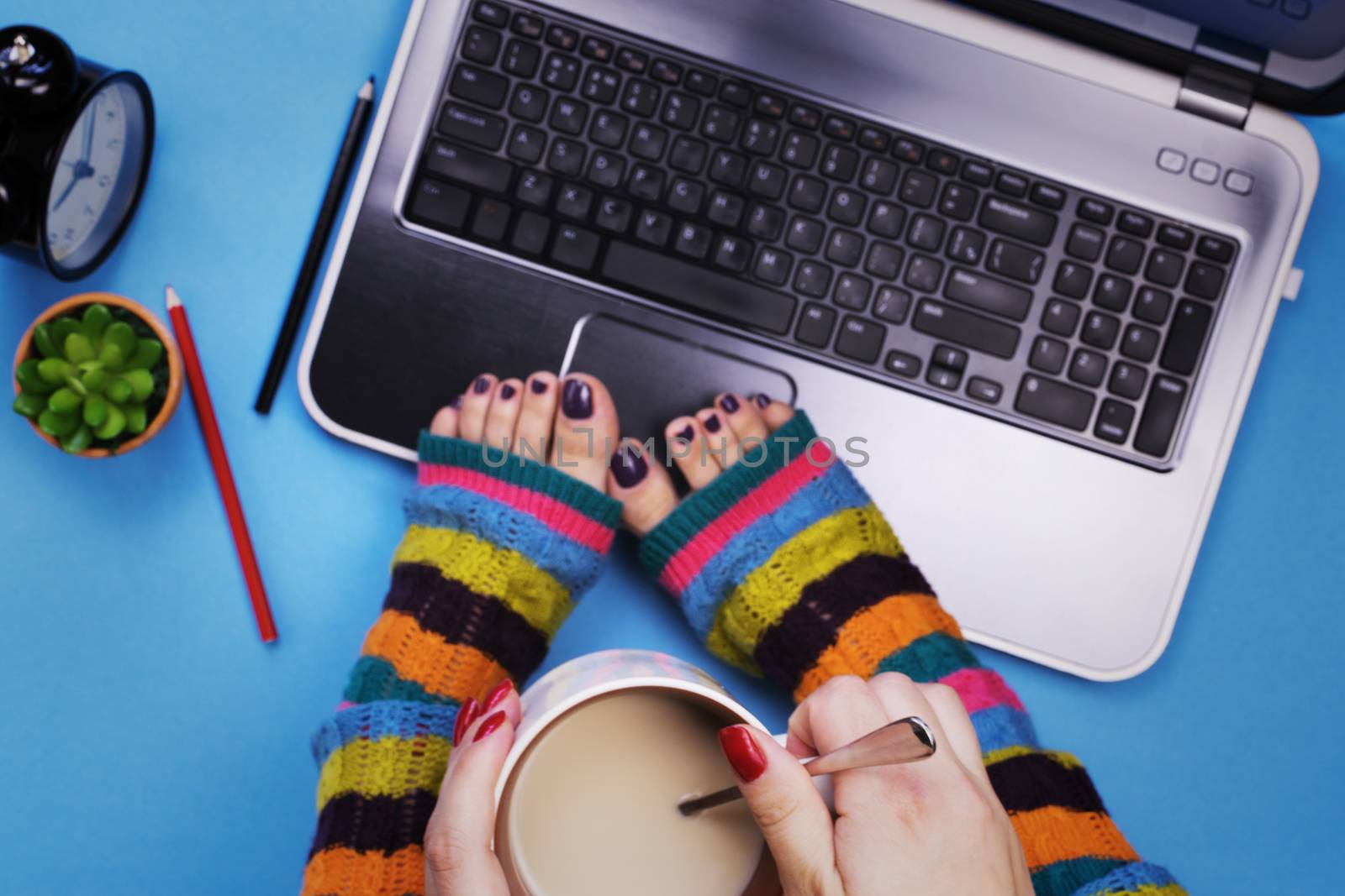 Female feet in socks on the computer. The concept of a woman and a computer.